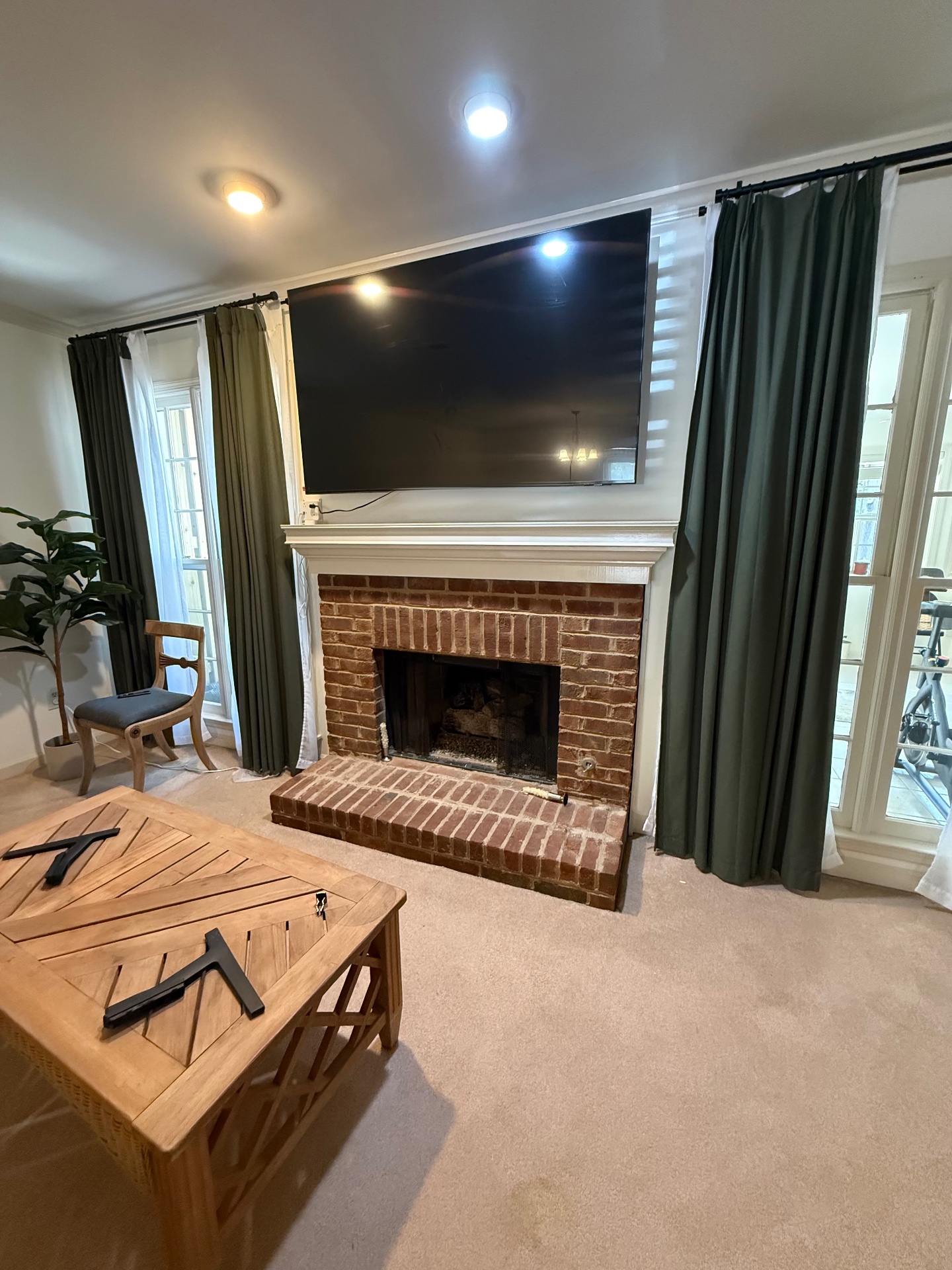 65-inch TV mounted above drywall fireplace in Atlanta, GA with MM340 MantelMount pull-down bracket