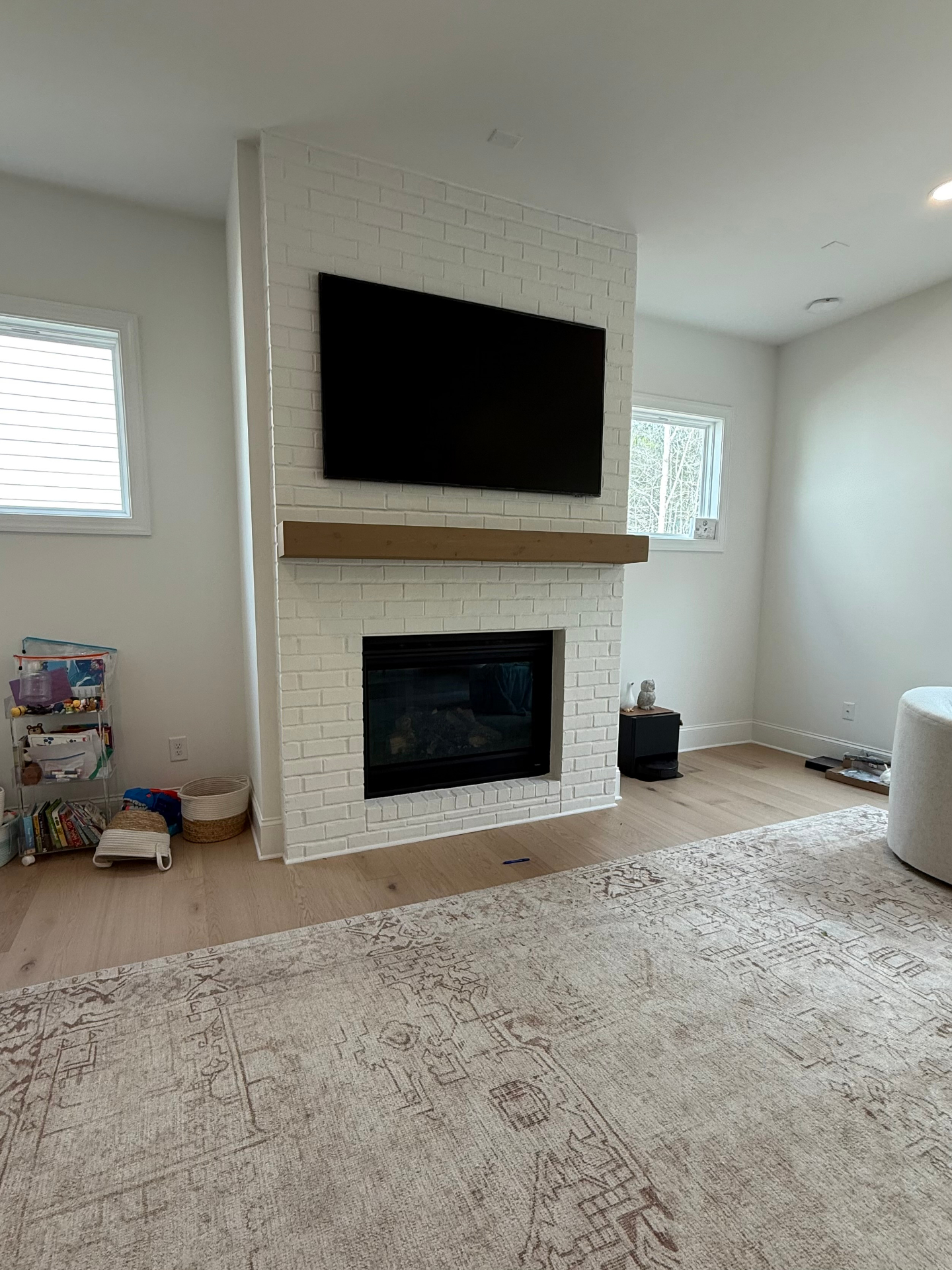 75-inch TV mounted above brick fireplace in Dallas, GA with tilt mount and cable concealment