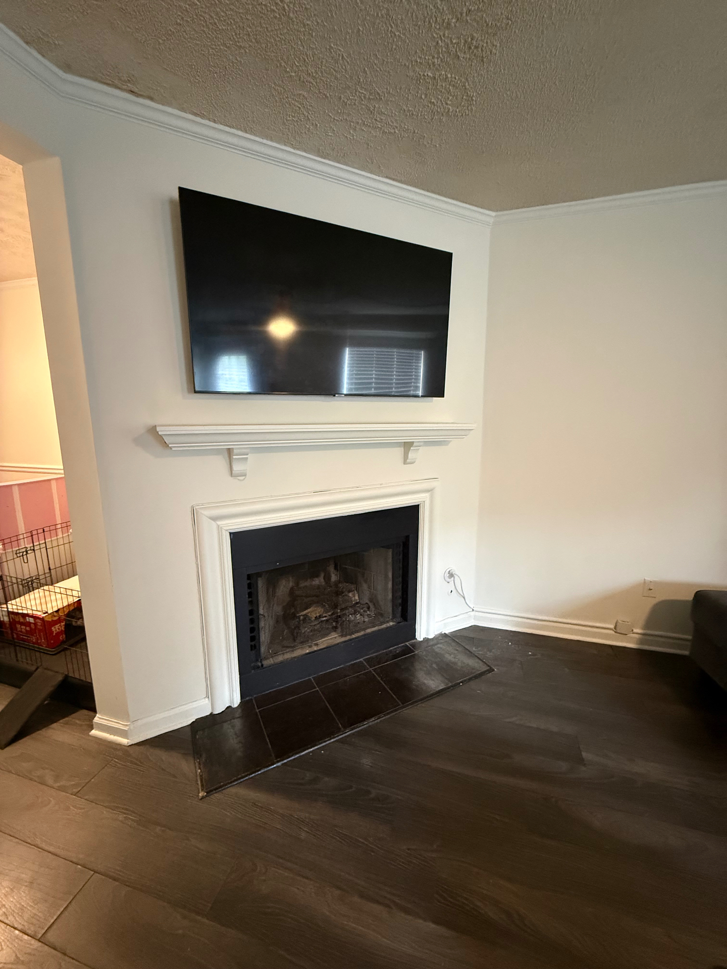 65-inch TV mounted above drywall fireplace in Kennesaw, GA with full-motion mount and in-wall electrical kit