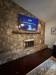 85-inch TV mounted on natural stone wall in Milton, GA with heavy-duty masonry anchors